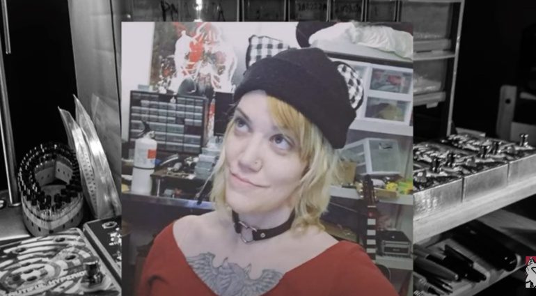 Devi Evers, a pretty blonde woman with a chest tattoo and a beanie on, in her studio.