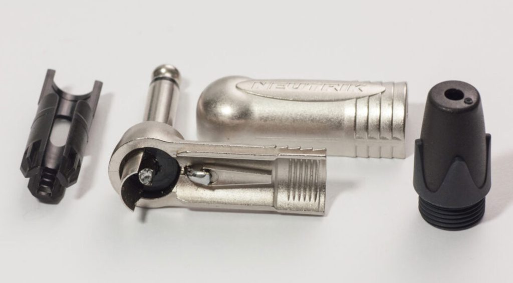 Closeup of the Neutrik angled jack connector: plug with slide-on housing (solder terminals already tinned), chuck, and boot